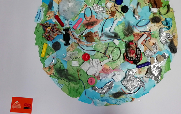 Pianeta Terra costruita con ritagli di carta e sulla quale sono stati sistemati diversi rifiuti