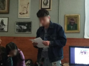 Ragazzo che legge davanti ad altri ragazzi