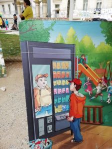 Bambino che vede il proprio riflesso diverso nel vetro della macchinetta delle merendine