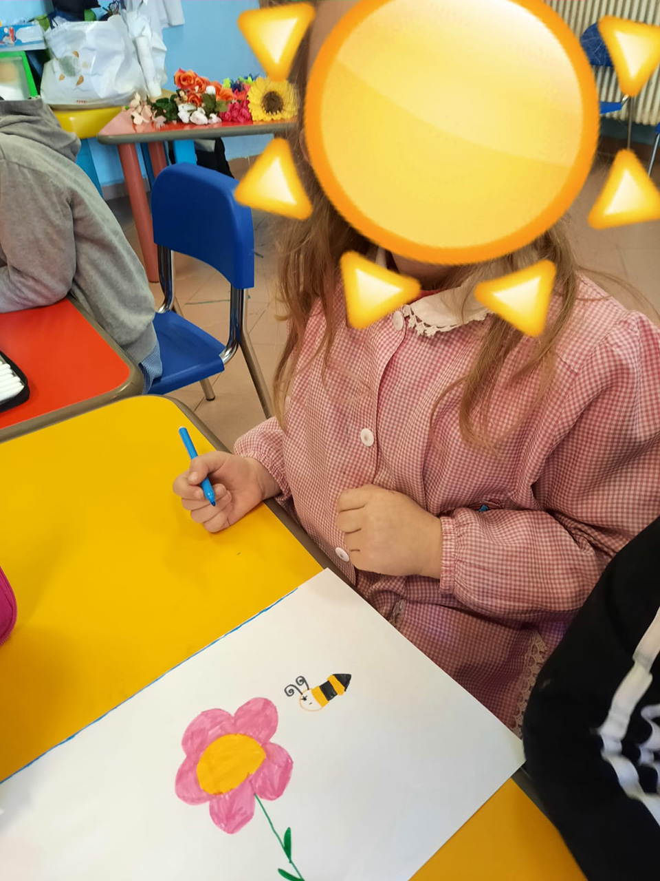 Bambina disegna un'ape e un fiore