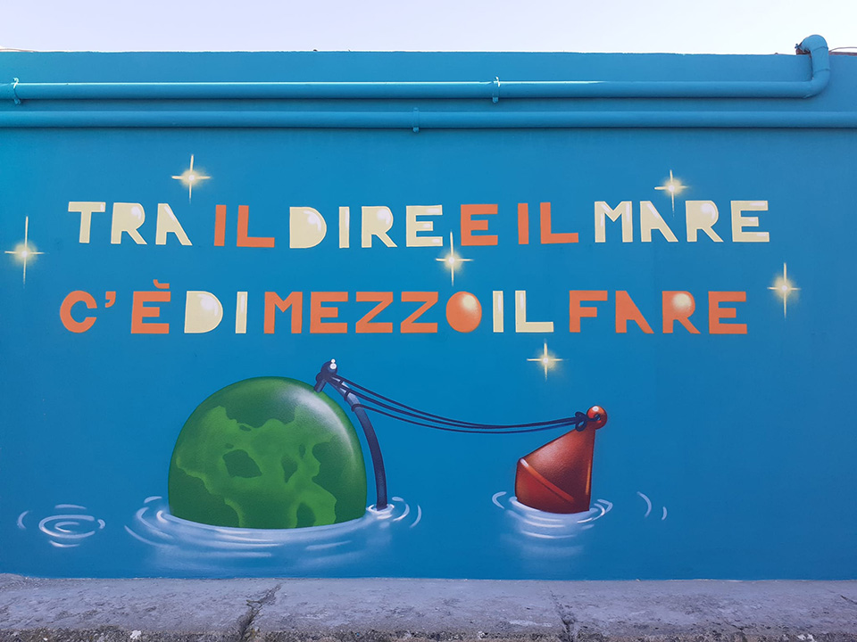 Murales con scritta tra il dire e il mare c’è di mezzo il fare Murales con scritta tra il dire e il mare c'è di mezzo il fare