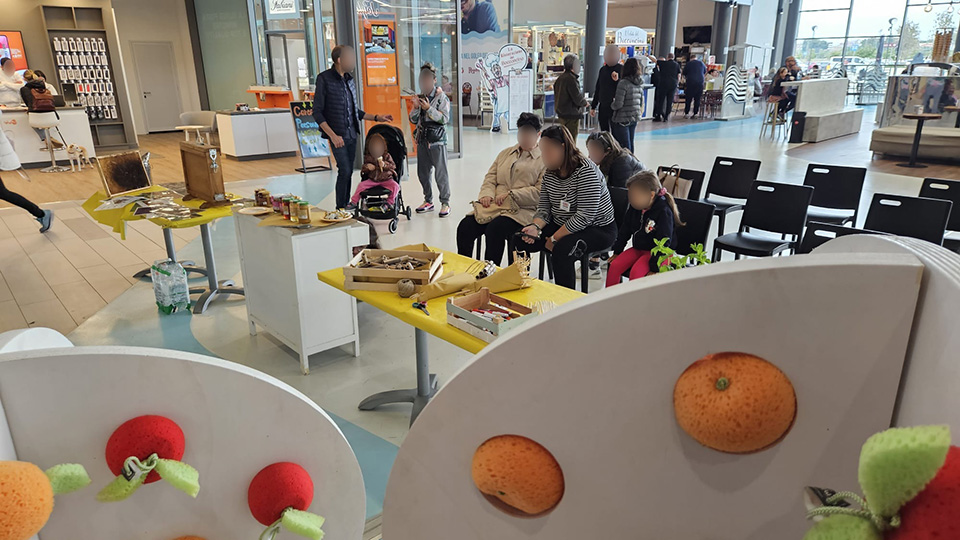 foto di persone, all'interno del centro commerciale, che guardano il favo
