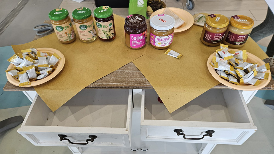 foto di un tavolo su cui sono presenti differenti mieli coop e cucchiaini