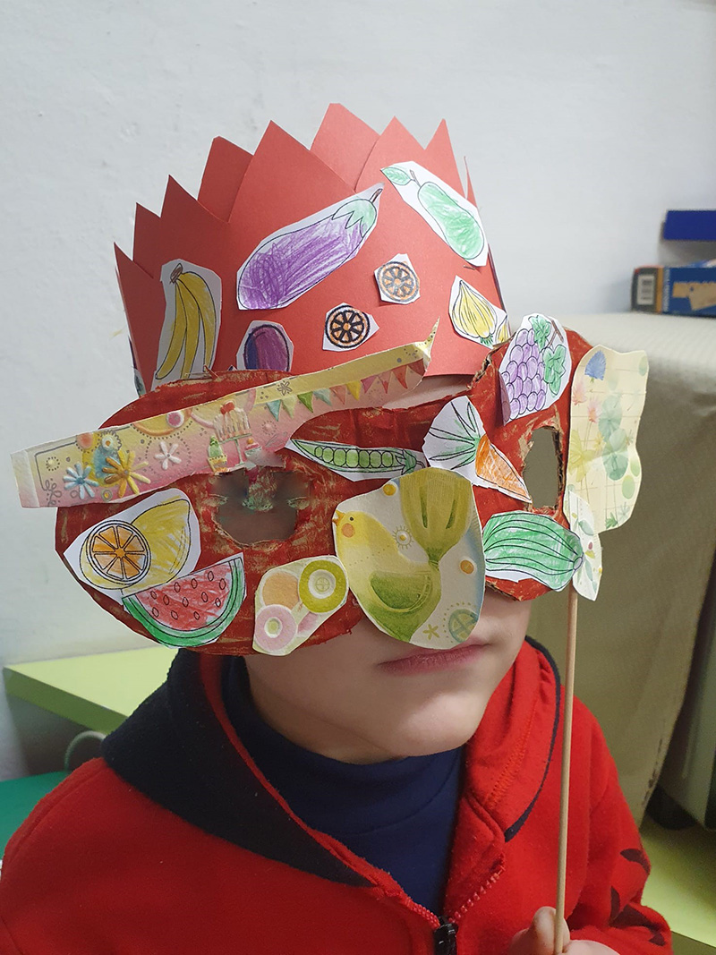 Bambino con cappello e maschera di carnevale Bambino con cappello e maschera di carnevale