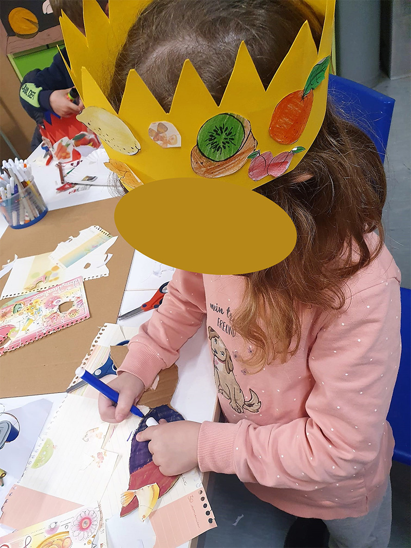 Bambina con corona decorata che disegna Bambina con corona decorata che disegna