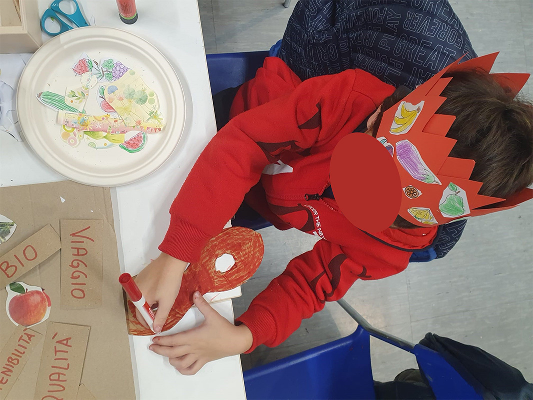Bambino con corona decorata che disegna Bambino con corona decorata che disegna