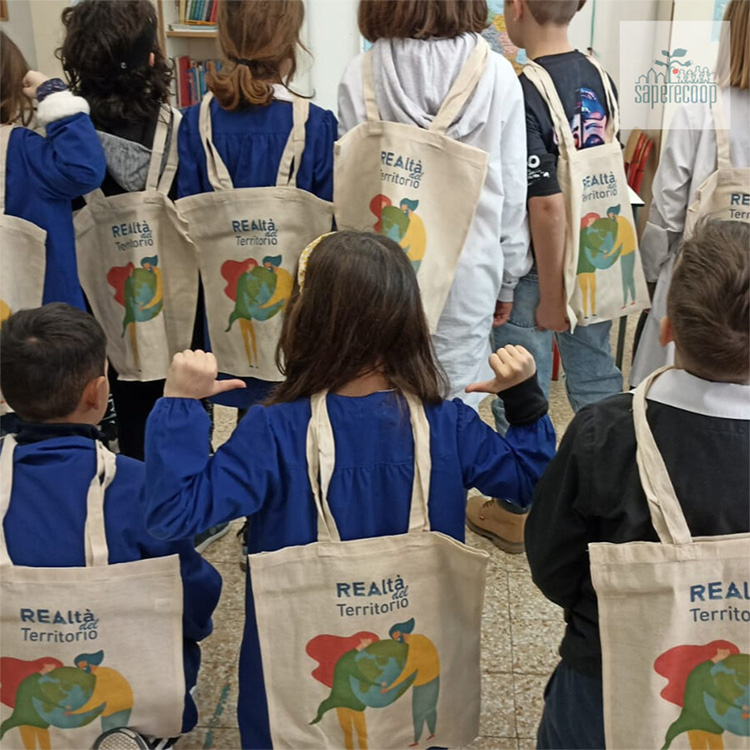 foto di bambini di spalle con una borsa realtà del terriitorio