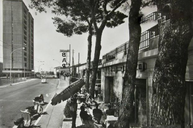 strada con un bar all’aperto, dove persone sono sedute ai tavolini sotto gli alberi. strada con un bar all'aperto, dove persone sono sedute ai tavolini sotto gli alberi.