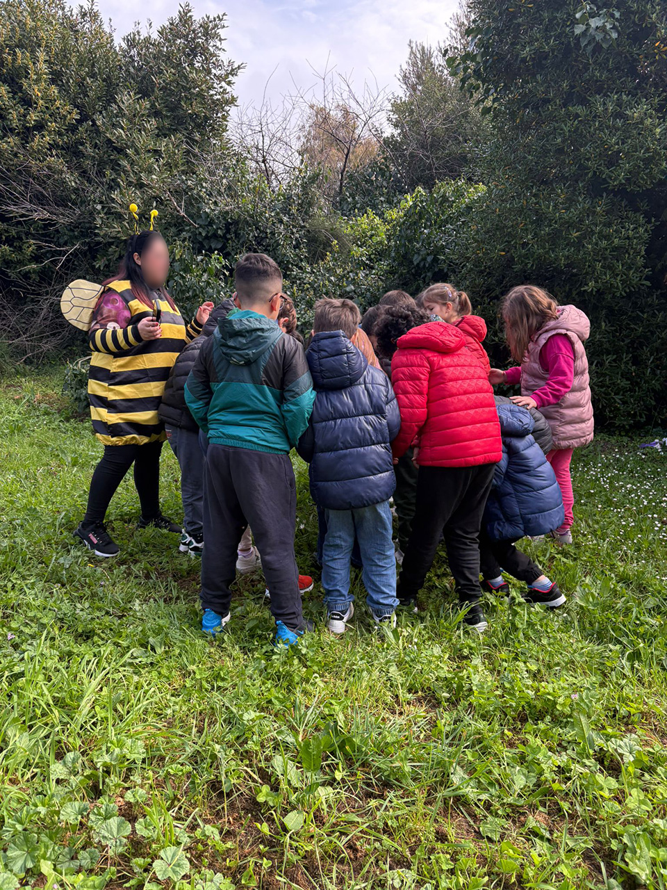 foto di bambini in cerchio e dona travestita da ape