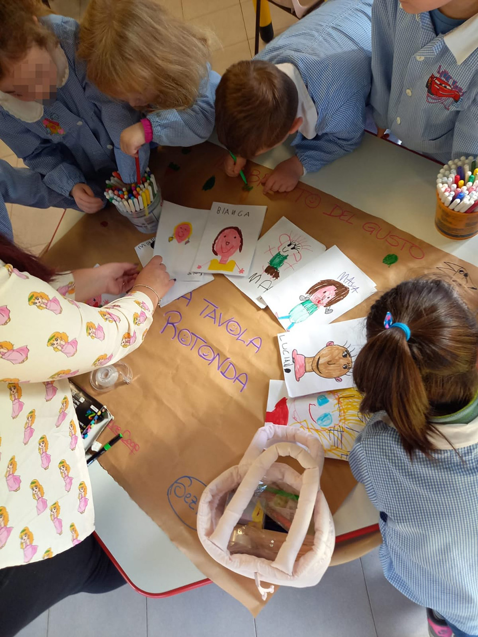 foto di bambini che creano un cartellone con disegni per progetto tavola rotonda