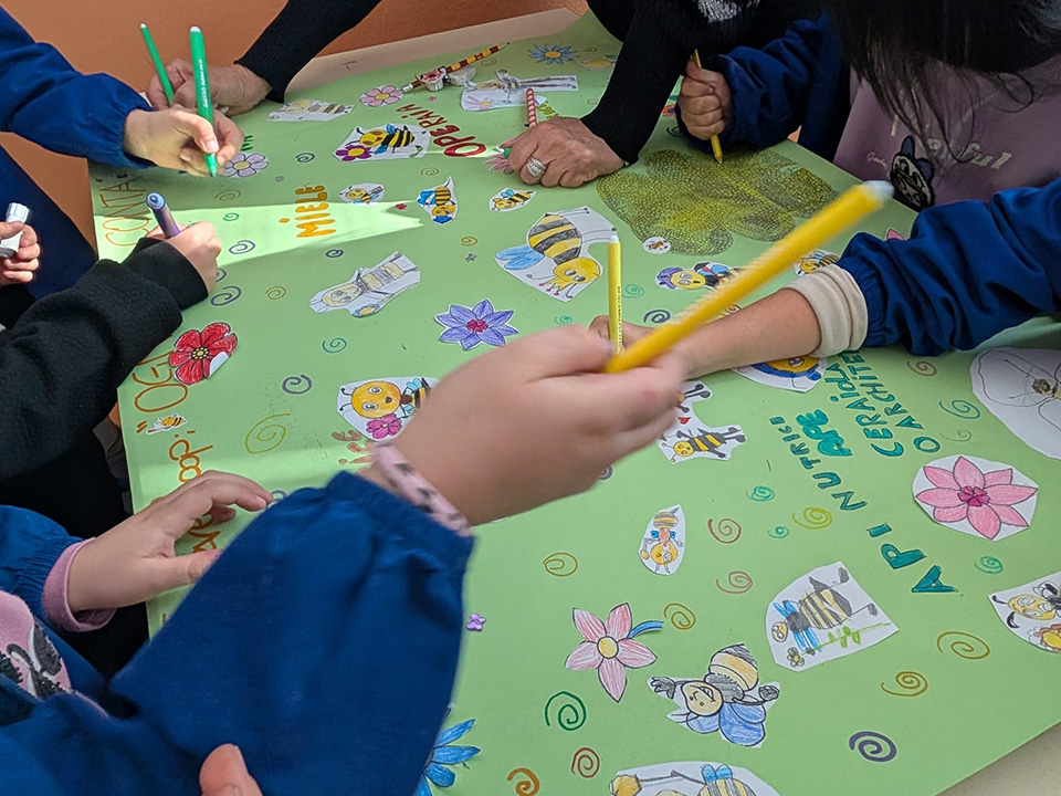 bambini che creano cartellone con api e fiori