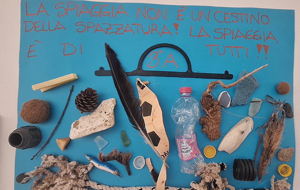 cartellone la spiaggia non è un cestino della spazzatura con diversi oggetti di plastica