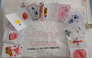 cartellone la tavola rotonda con disegni creati da bambini
